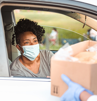Woman receives food donation during coronavirus crisis